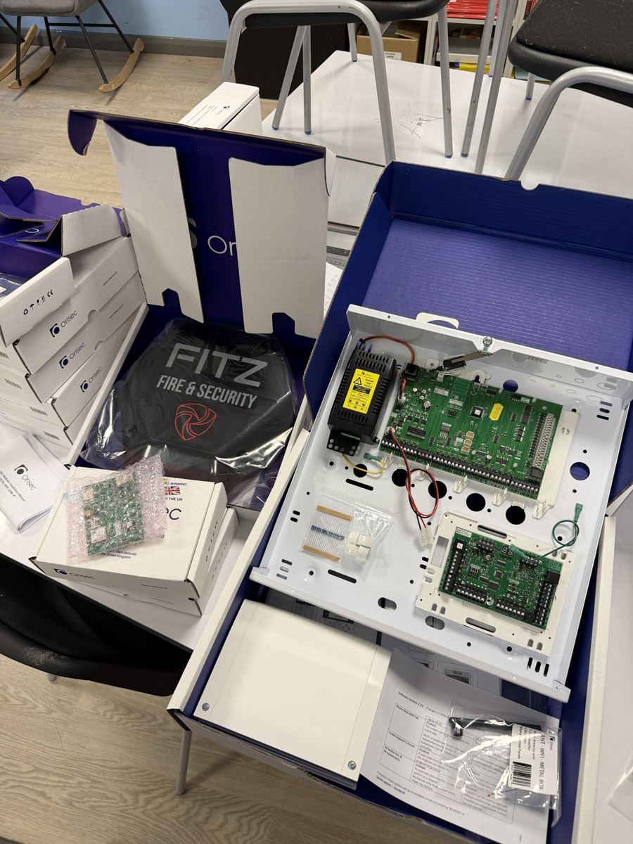 New alarm control panel opened up for installation, next to a Fitz-branded bag